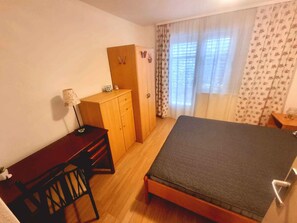 A room with a bed, a desk, and a wardrobe.
