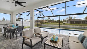 Un patio al aire libre con piscina, zona de estar y vistas del vecindario.