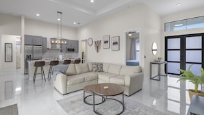 Amplia sala de estar con sofá modular, una mesa de centro y una cocina al fondo.