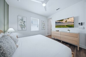 A bedroom with a bed, a dresser, a television, and artwork on the wall. - Glamorous Getaway With Themed Bedrooms at Reunion (Kissimmee)