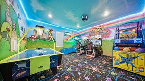 Ein farbenfroher Spielsalon mit verschiedenen Spielautomaten, darunter ein Rennspiel und ein Basketballspiel.