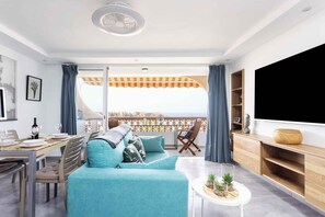 A modern living room with a sofa, dining table, and TV. - Holiday apartment with gorgeous sea view (Palm Mar)