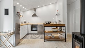 A modern kitchen with a built-in oven, microwave, and stainless steel appliances. - 3 bedroom pet friendly home in Græsted (Græsted)