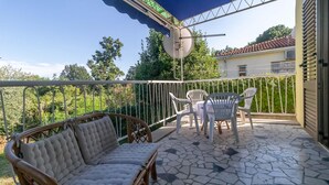 A covered outdoor patio with a sofa, chairs, and a table. - 3 bedroom cozy apartment in Ika (Ika)