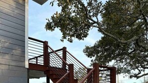 Una escalera de madera con barandas de metal que conduce a la entrada de un edificio.