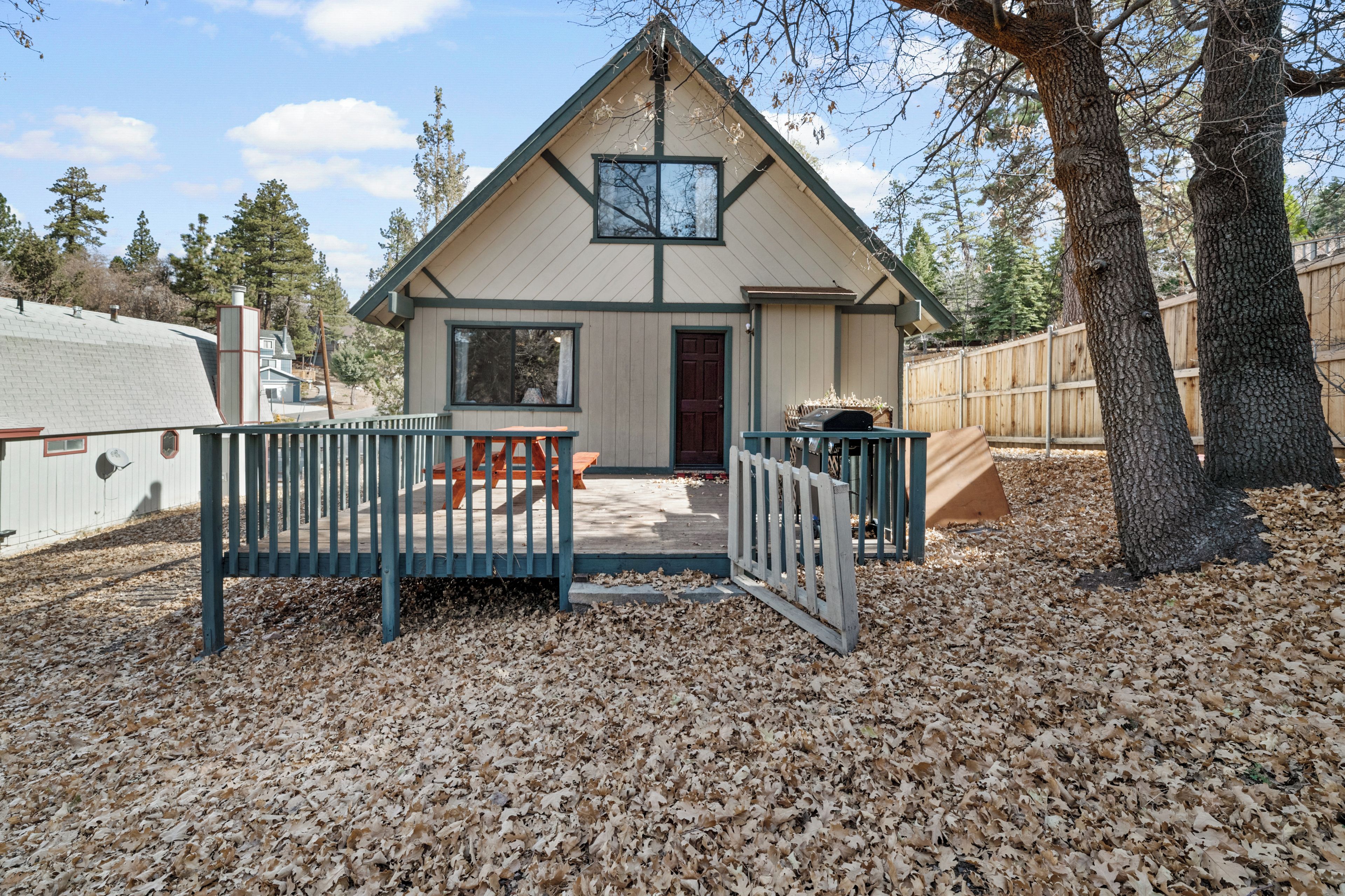 A single-story house with a front porch, a small deck, and a covered outdoor seating area.