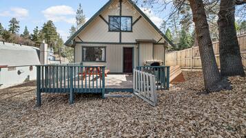 A single-story house with a front porch, a small deck, and a covered outdoor seating area.