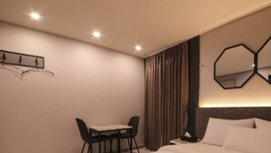 A modern hotel room with a bed, a desk, and two wall-mounted mirrors. - Hotel ONO (Incheon)