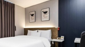 A hotel room with a bed, a nightstand, a chair, and a window with curtains. - Hotel ONO (Incheon)