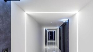 A modern, well-lit hallway with a sign indicating the location. - Hotel ONO (Incheon)