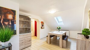 Een moderne keuken met een eethoek, dakraam en een potplant.
