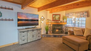 Una sala de estar acogedora con chimenea, televisor y sofá.