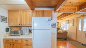 Una cocina con armarios de madera, un refrigerador blanco y una tostadora.