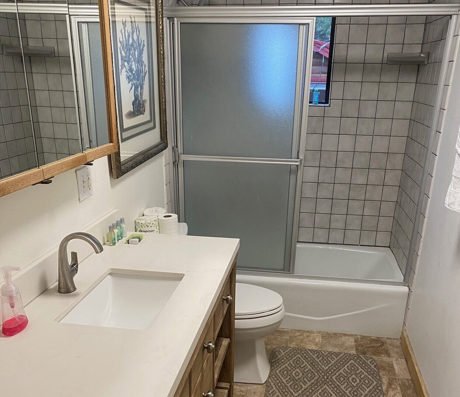 A bathroom with a shower, toilet, and sink.