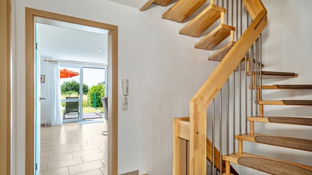 A wooden staircase with a handrail, leading to an open door. - Holiday Home 'Storchennest' with Private Terrace, Private Garden and Wi-Fi (Markdorf)