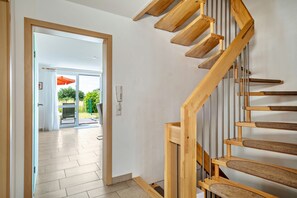 A wooden staircase with a handrail, leading to an open door. - Holiday Home 'Storchennest' with Private Terrace, Private Garden and Wi-Fi (Markdorf)