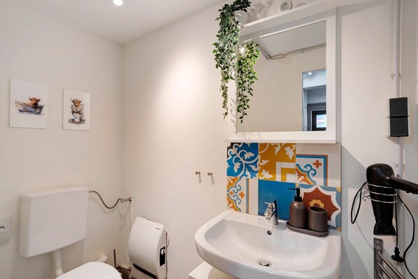 Un baño con inodoro, lavabo y espejo.