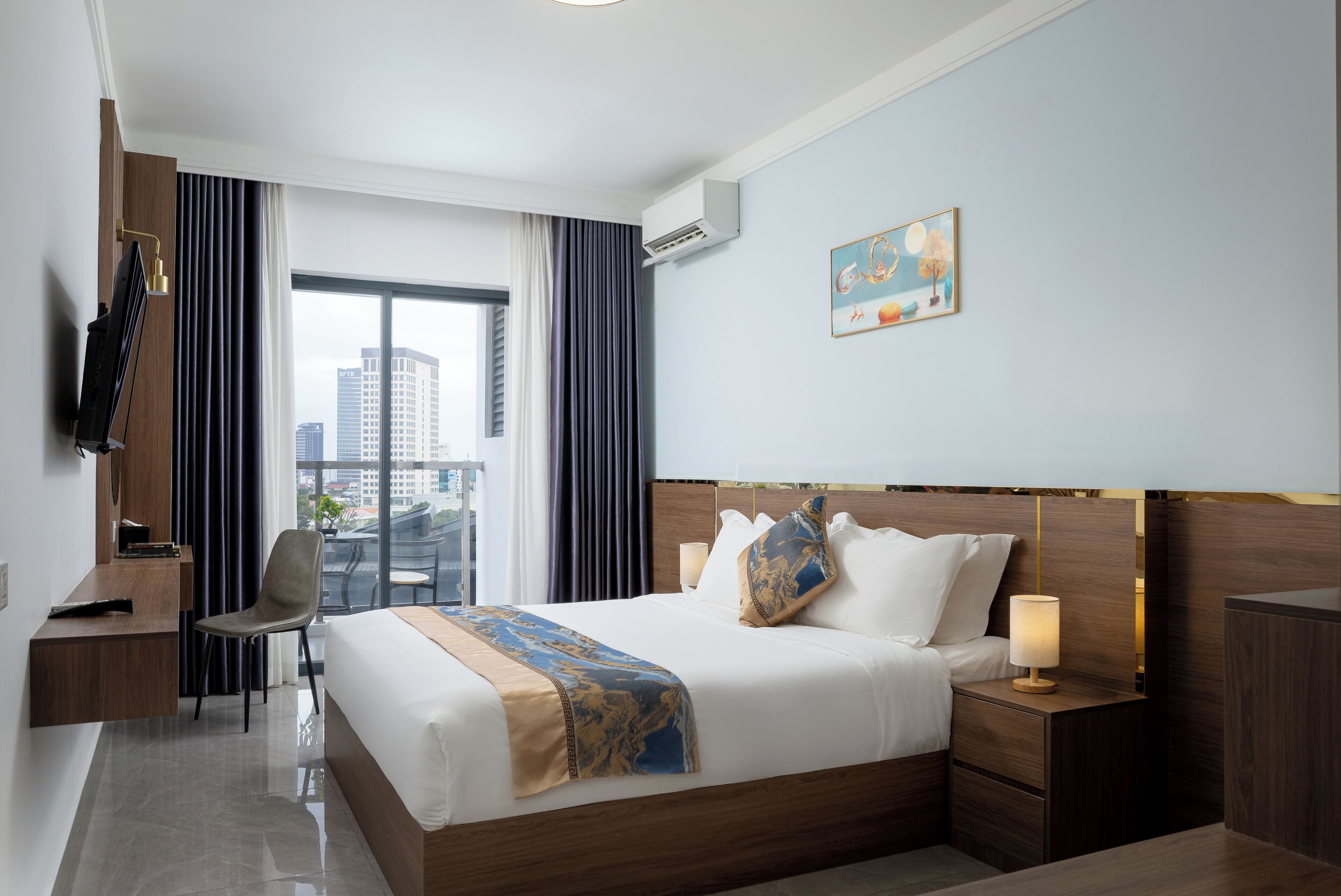 A hotel room with a bed, bedside table, chair, and a large window with curtains.