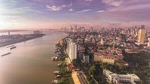 A coastal cityscape with dense urban development, a river, and a mix of high-rise and low-rise buildings.