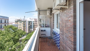 Un balcón con vista a la ciudad, una ventana y una puerta.