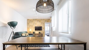 Una sala de estar moderna con una mesa de comedor, sofá y lámpara de pie.