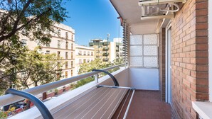 Ein Balkon mit Wäscheständer, Backsteinwänden und Blick auf benachbarte Gebäude.