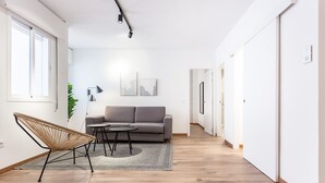 Una sala de estar moderna con un sofá, un sillón y una mesita.