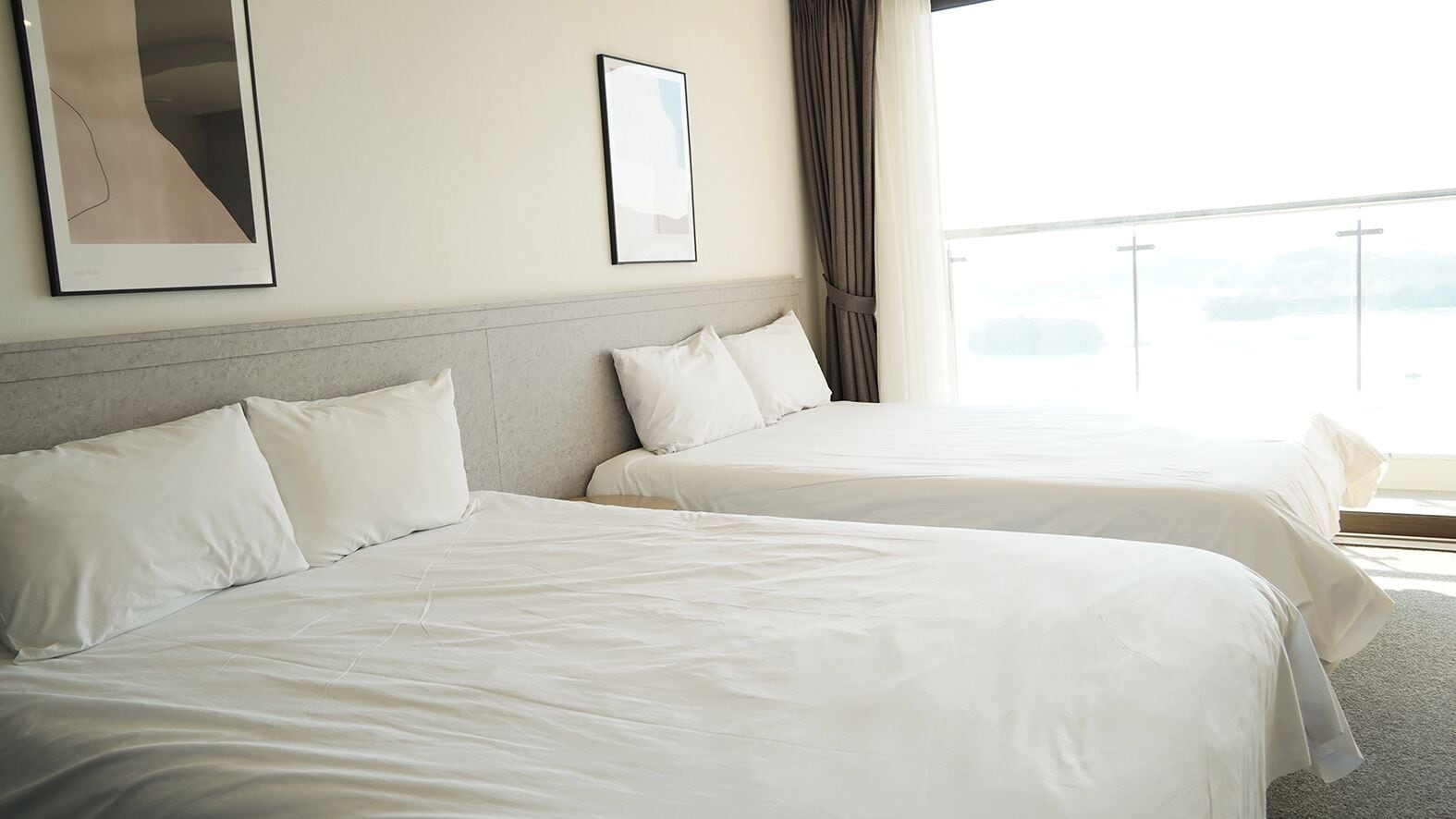 Two single beds with white linens in a hotel room.