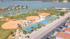 Ein Luftbild eines Sportkomplexes mit einem Baseballfeld, Tennisplätzen und einem Parkplatz.