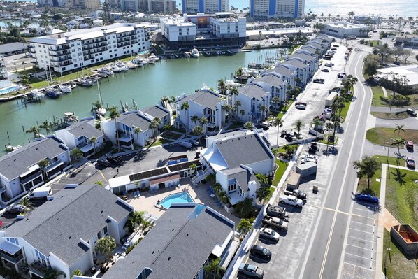 A coastal hotel with multiple buildings, a marina, and a swimming pool. - Resort Style Community. Quick Walk to Beach. Heated Pool. Near Great Restaurants & Shops. (Madeira Beach)