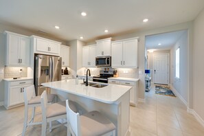 Enjoy cooking in this well-equipped kitchen with a central island, stainless steel appliances, and ample counter space.