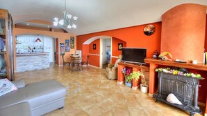 A spacious living room with a fireplace, a television, and a dining area.