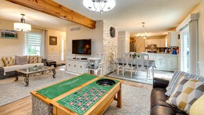 A spacious living room with a pool table, a sofa, a television, and a kitchen in the background. - Hot Tub, Game Room & Fire Pit: Pocono Summit Home! (Pocono Summit)