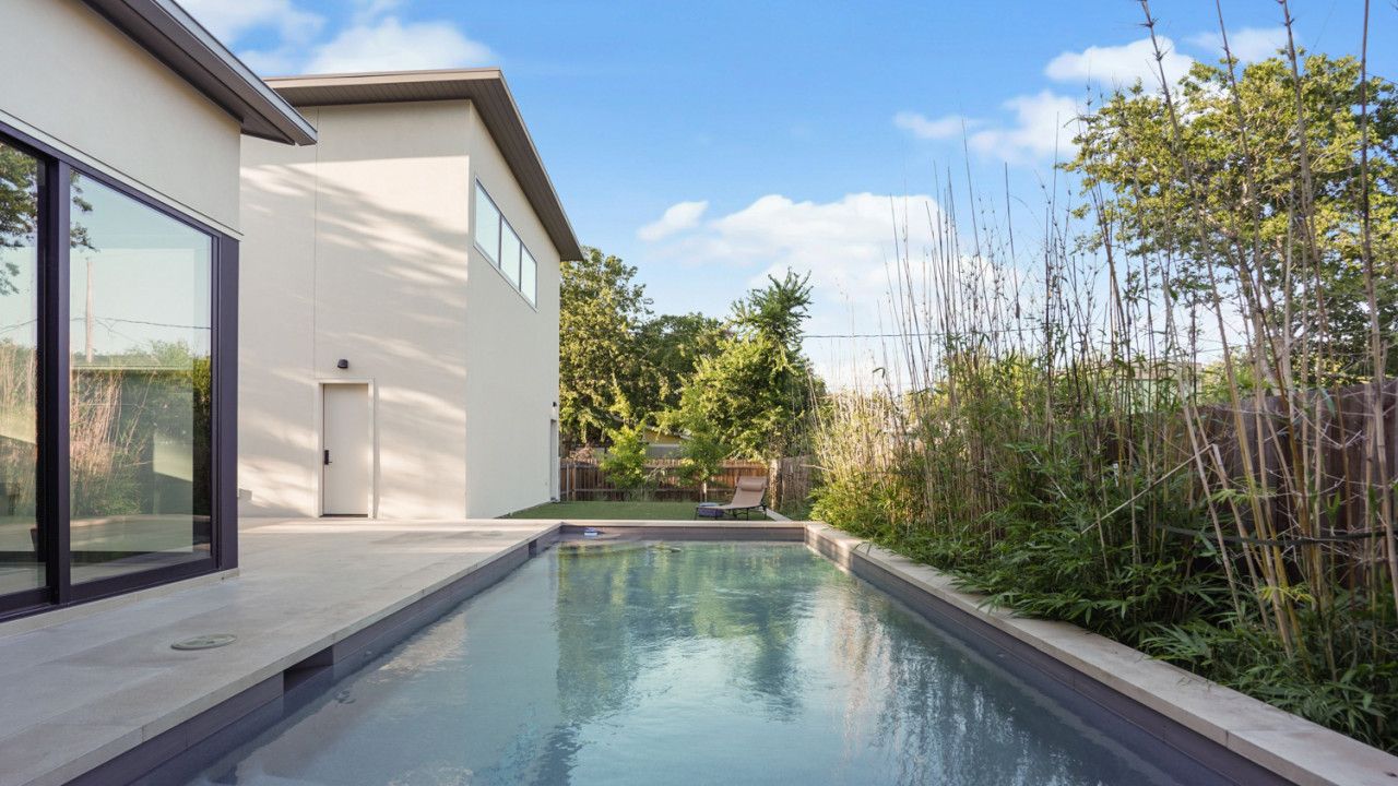 Una casa moderna con piscina, una porta e una finestra.