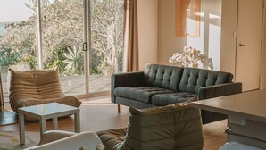 Un salon moderne avec un canapé, des fauteuils et une table basse.
