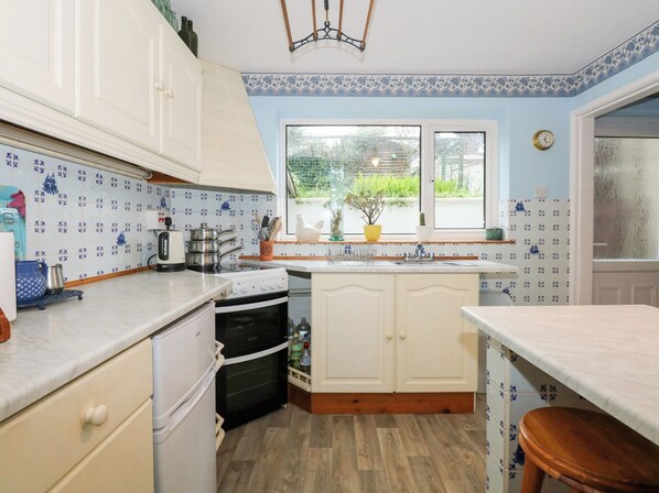 Enjoy cooking in this well-equipped kitchen with a central island, oven, and sink.