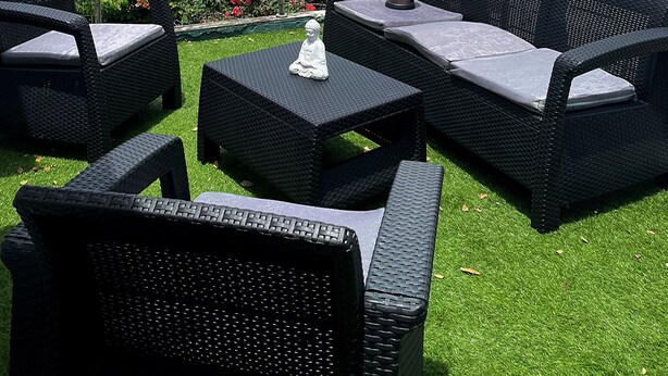 A rooftop terrace with outdoor furniture, a Buddha statue, and a view of the cityscape. - Historic Ocean Park Near Beach Water Reserve Fiber Internet Fast WiFi (San Juan)