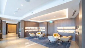 A modern lobby with a reception desk, seating area, and display shelves. - Vogue, Downtown Opera Grand near Burj Khalifa & Dubai Mall, with Fountain view (Dubai)