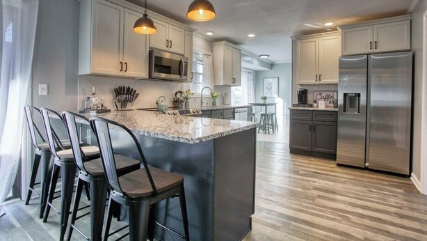 A modern kitchen with a central island, bar stools, stainless steel appliances, and pendant lighting. - Decatur Rocksteady Message for Summer Special (Decatur)
