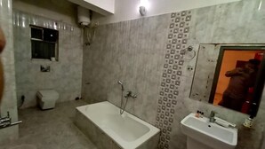 Un baño con bañera, lavabo y ducha.