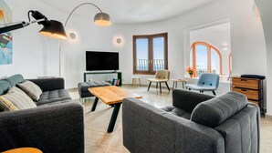 A modern living room with a sofa, coffee table, and TV. - Villa 'Costa Blanca' with Sea View, Wi-Fi and Air Conditioning (Benitachell)