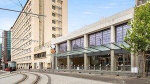 Una estación de tranvía con un edificio moderno que dice 