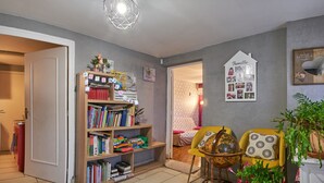 Ein Zimmer mit Bücherregal, Globus, gelbem Sessel und einer Wand voller Familienfotos.