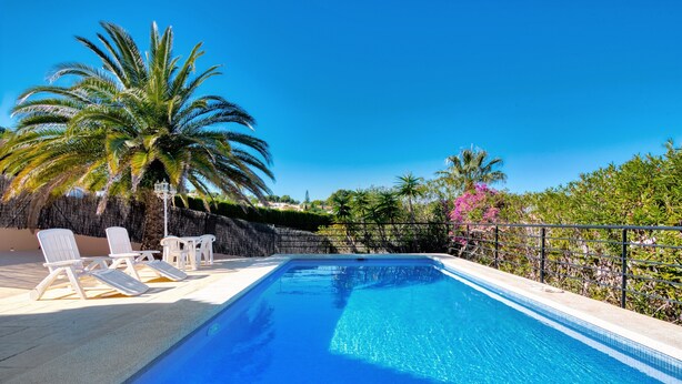 A swimming pool with lounge chairs, palm trees, and a clear blue sky. - Villa 'Alta' with Private Pool, Wi-Fi and Air Conditioning (Dénia)