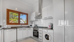 A modern kitchen with white cabinetry, a built-in oven, a microwave, a dishwasher, and a washing machine. - Villa 'Alta' with Private Pool, Wi-Fi and Air Conditioning (Dénia)