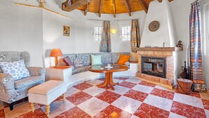 A cozy living room with a checkered floor, a fireplace, a sofa, and a wooden ceiling. - Villa 'Nicoll' with Private Pool, Wi-Fi and Air Conditioning (Dénia)
