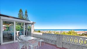 A terrace with a table and chairs, a glass door, and a view of the sea. - Villa 'Nicoll' with Private Pool, Wi-Fi and Air Conditioning (Dénia)