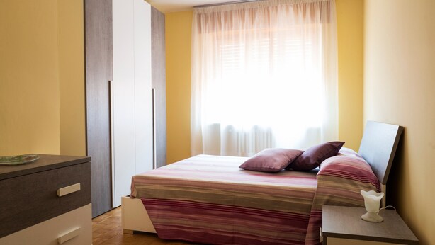 A bedroom with a bed, bedside tables, a dresser, and a window with curtains. - Apartment "Semia" with Mountain View, Balcony & Wi-Fi (Vinadio)