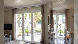 A spacious living area with a sofa, a coffee table, and a television. - Holiday Home 'Los Barqueros 13' with Shared Pool, Private Terrace & Wi-Fi (Corralejo)