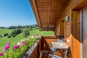 A wooden balcony with a table and chairs, overlooking a green landscape. - Holiday Apartment 'Mongaduierhof Apt Schlern' with Mountain View, Shared Garden & Wi-Fi (Fie' allo Sciliar)